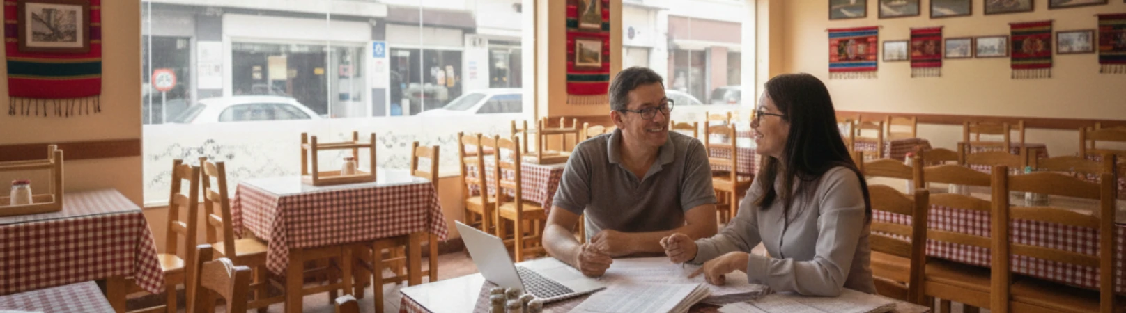 Pareja revisando checklist de software en un restaurante vacío